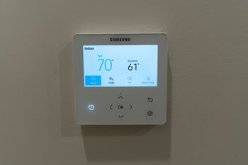 A Samsung thermostat shows the indoor temperature as 70 degrees and the current temperature as 61 degrees.